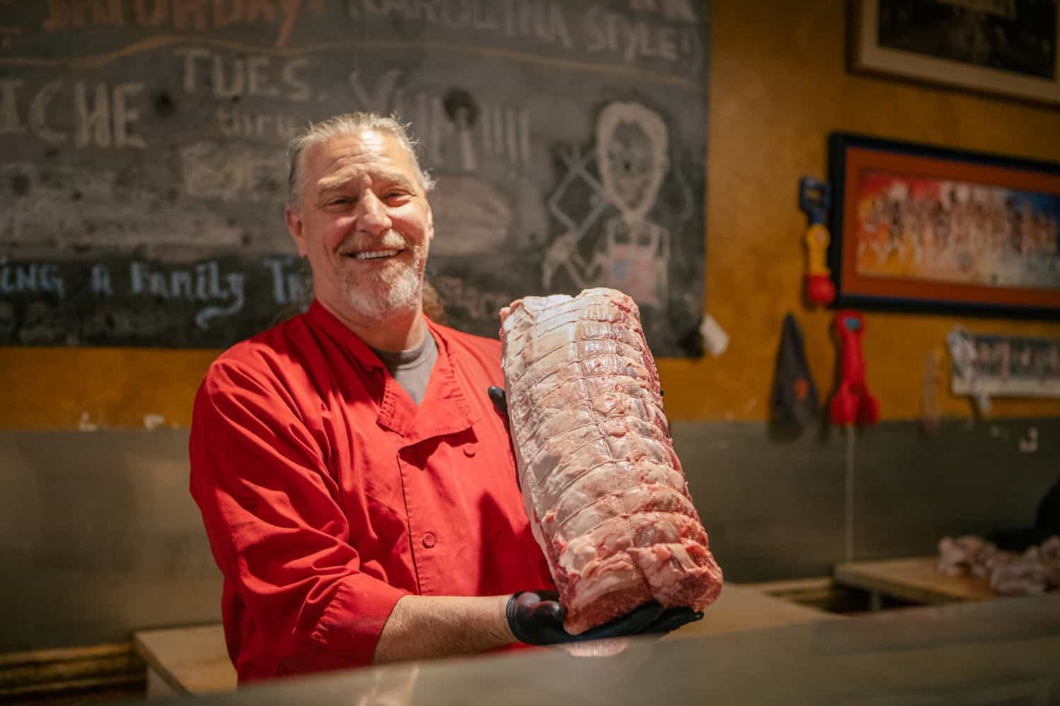 Butcher holding slab of meat